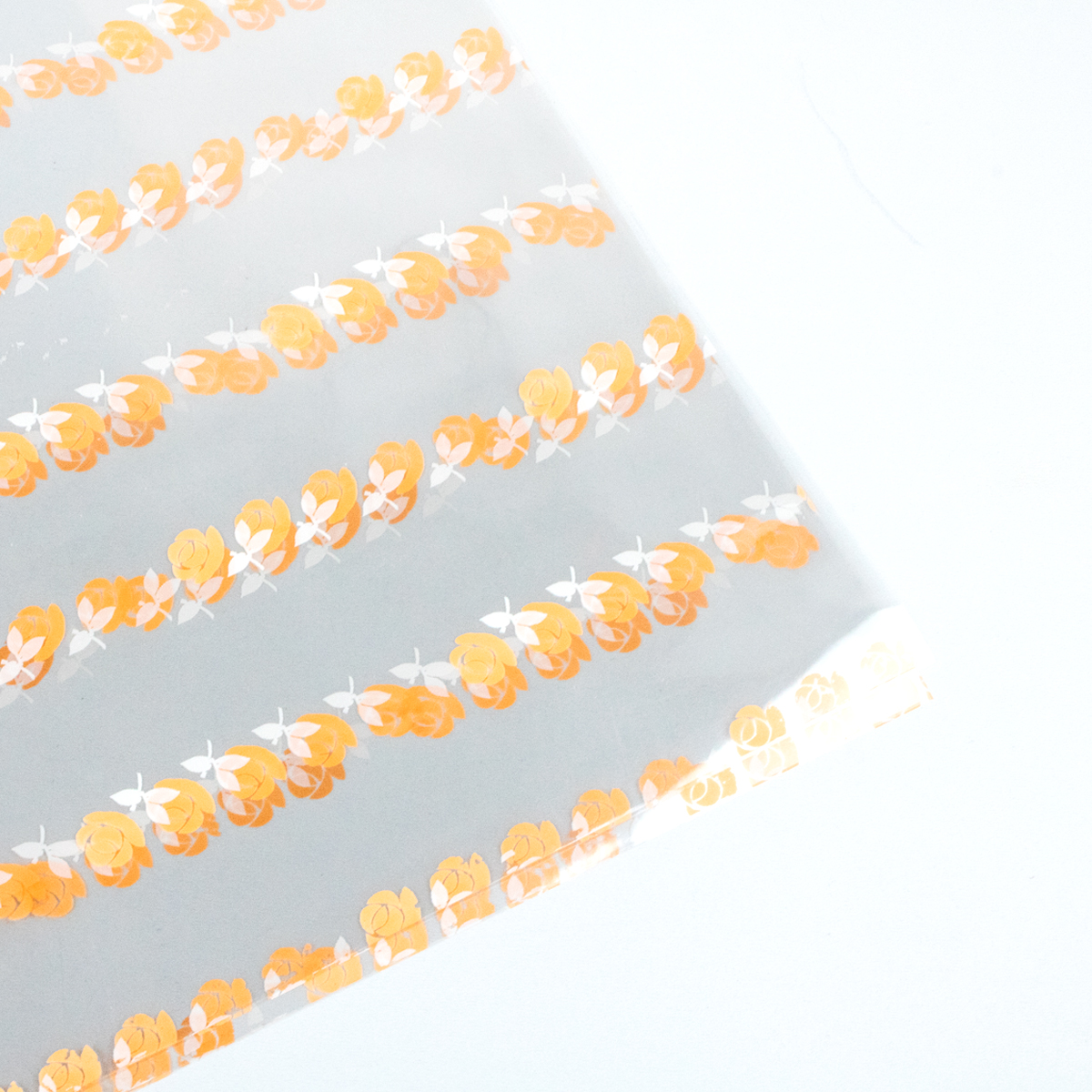 Papel celofan con diseño de patrón de rosas pequeñas naranjas